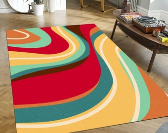 May include: A rectangular area rug with a retro design. The rug features a vibrant color palette of red, yellow, teal, brown, and cream in a swirling, abstract pattern. The rug is placed on a hardwood floor.