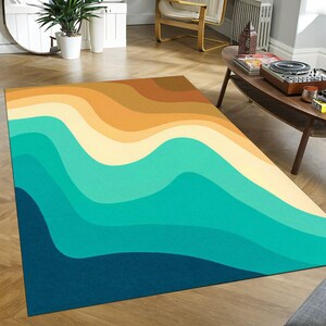 Pode incluir: Tapete de área abstrato com um padrão ondulado em tons de azul, verde, amarelo e marrom. O tapete tem um design moderno e geométrico.