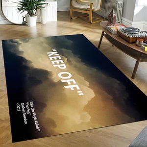 Può includere: Tappeto rettangolare con un design a cielo nuvoloso nei toni del blu, oro e marrone. Le parole "KEEP OFF" sono stampate in grandi lettere bianche. Il tappeto include anche il testo "IKEA c/o Virgil Abloh™ Flooring Almhult Sweden c 2019."