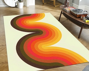 Op de afbeelding: Een rechthoekig vloerkleed met een retro-ontwerp. Het kleed heeft een crèmekleurige achtergrond met een golvend, gestreept patroon in tinten bruin, rood, oranje en geel. Het kleed ligt op een houten vloer in een woonkamer.