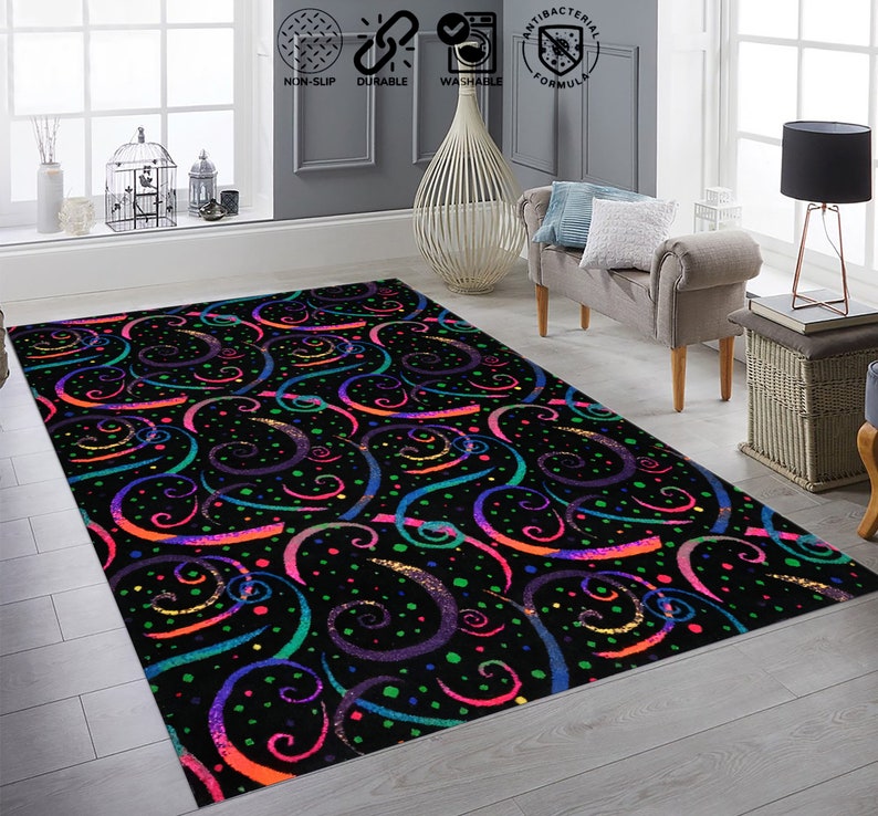 May include: A black area rug with a colorful swirl pattern. The rug has a black background with swirls of pink, blue, green, and yellow. The rug is decorated with small white dots.