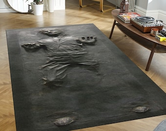 May include: A gray rug with a black and white image of Han Solo frozen in carbonite. The rug is on a wooden floor.
