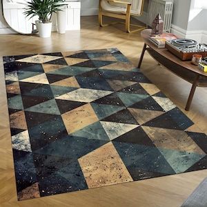 May include: A rectangular area rug with a geometric pattern of triangles in shades of blue, brown, and beige. The rug has a distressed, textured appearance, adding a vintage or industrial feel. The rug is placed on a wooden floor.