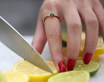 Puede incluir: Una mano con uñas rojas utiliza un cuchillo plateado para cortar un limón en rodajas. Las rodajas de limón están dispuestas en una tabla de cortar blanca con rodajas de lima.