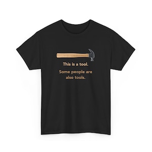 Könnte beinhalten: Schwarzes T-Shirt mit Hammer-Grafik und dem Text "This is a tool. Some people are also tools." Der Hammer hat einen Holzgriff und einen silbernen Kopf. Ein humorvolles Design für Heimwerker.