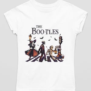 May include: White t-shirt with a graphic of a band of spooky characters walking across a crosswalk. The text "The Boo-tles" is above the graphic.