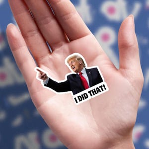 May include: A sticker featuring a smiling man in a black suit and red tie, pointing with his right index finger. The sticker has the text "I DID THAT!" in bold, white letters.