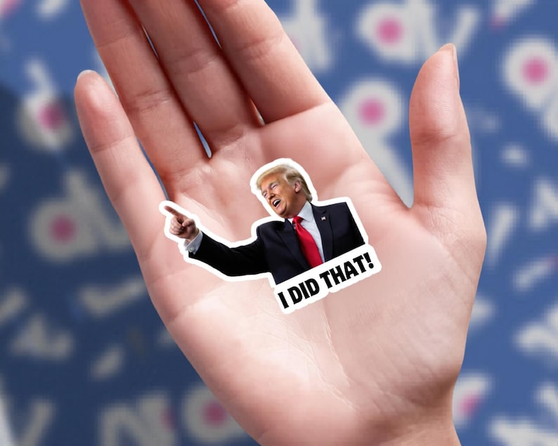 May include: A sticker featuring a smiling man in a black suit and red tie, pointing with his right index finger. The sticker has the text "I DID THAT!" in bold, white letters.