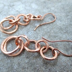 <img src=“earrings.jpg" alt="Boho style long drop earrings with hand forged copper chain link dangles of interlocking rings"