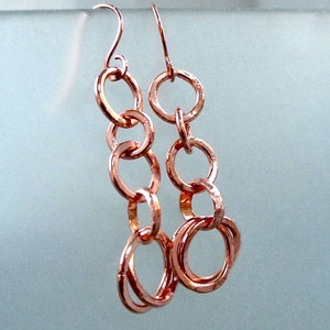 With copper ring dangles, long earrings with open circle chain links make a lively and rustic boho statement in hand forged jewelry for women.