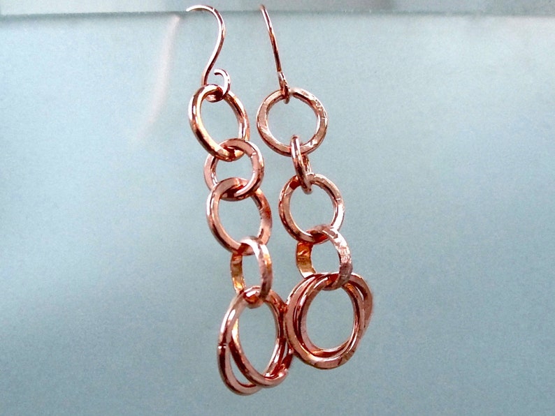 With copper ring dangles, long earrings with open circle chain links make a lively and rustic boho statement in hand forged jewelry for women.