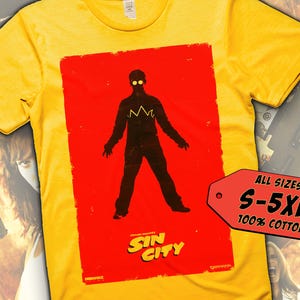 Peut inclure: T-shirt jaune avec un graphique rouge d'une silhouette d'une personne portant une couronne et des lunettes. Le graphique dit "Sin City".