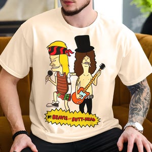May include: White t-shirt with a cartoon image of Beavis and Butt-Head dressed as rock stars. Beavis is holding a microphone and Butt-Head is playing a guitar. The text "Beavis and Butt-Head" is printed below the image.