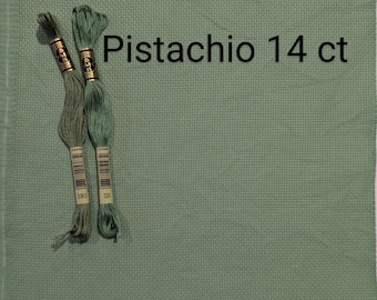 Op de afbeelding: Een stuk pistachegroen Aida-doek met twee klosjes groene borduurgaren. Het garen is geëtiketteerd met de nummers 320 en 3363. De tekst "Pistachio 14 ct" is op het doek gedrukt.