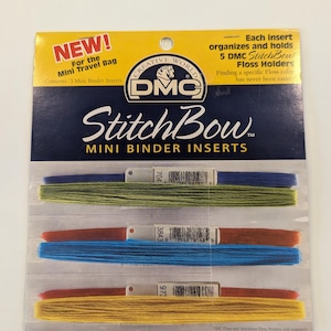 Puede incluir: Un paquete de DMC StitchBow Mini Binder Inserts. El embalaje es amarillo y azul, con el logotipo de DMC y el texto "&iexcl;NUEVO!" y "Mini Binder Inserts". Contiene cinco colores diferentes de hilo de bordar: azul, verde, rojo y amarillo.