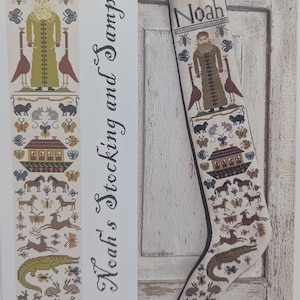 May include: A cross-stitch Christmas stocking with the name "Noah" at the top. The design features a figure, animals, and a house, all in a folk art style. The words "Noah's Stocking and Sampler" are also visible.