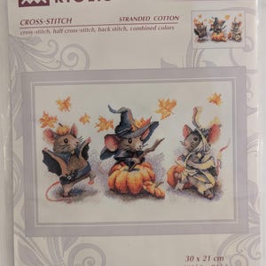 May include: A cross-stitch kit featuring a "Spooky Mouse Trio" design. The image shows three mice dressed in Halloween costumes, with pumpkins and autumn leaves. The kit dimensions are 11 3/4" x 8 1/4". The brand is RIOLIS.