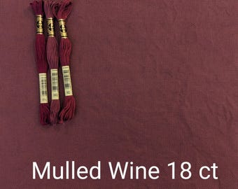 May include: Three spools of embroidery floss in shades of red, labeled with numbers 3802, 3803, and 3814. The floss is against a dark red fabric background. The text "Mulled Wine 18 ct" is printed below the floss.