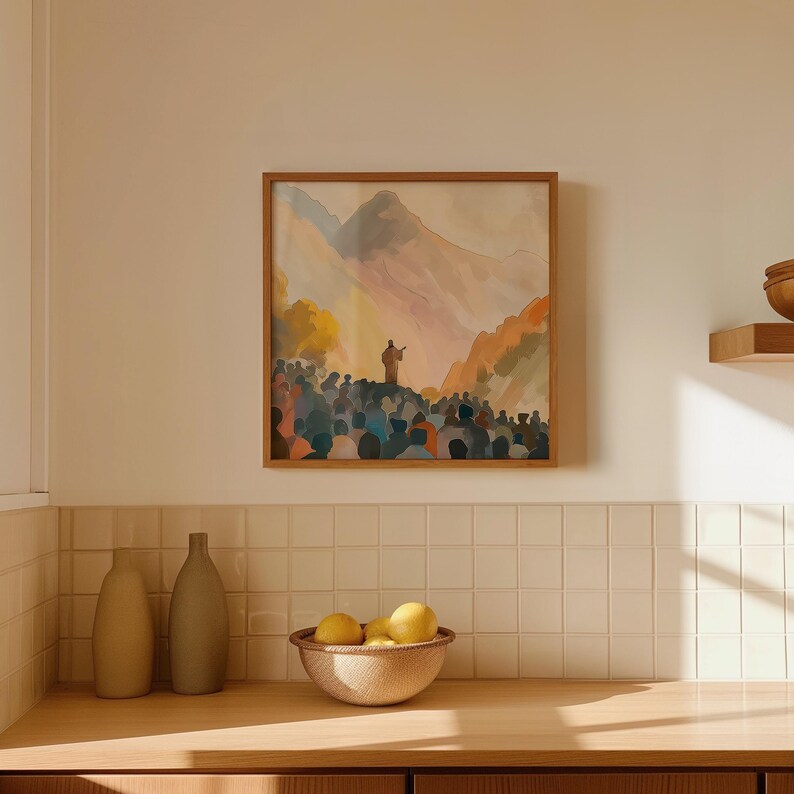 May include: A framed watercolour painting showing a figure addressing a crowd against a mountain backdrop. The artwork uses warm orange, yellow, and blue tones, creating a calm atmosphere. The painting is displayed above a wooden countertop, with a bowl of lemons.