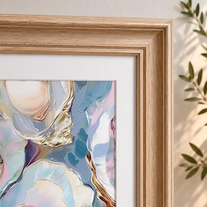 May include: Abstract art print in a light wood frame. The artwork features a colorful, flowing design with shades of blue, pink, gold, and white. The frame is a light, natural wood color, and the print is matted with a white border.