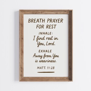 Può includere: Una stampa incorniciata con il testo "BREATH PRAYER FOR REST". Il testo include "INHALE: I find rest in You, Lord." e "EXHALE Away from You is weariness." La stampa è in una cornice di legno.