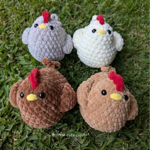 May include: Four handmade crochet chickens in grey, white, brown, and tan. Each chicken has a red comb, yellow beak, and black eyes. The chickens are on green grass, and the text "sew cute crochet" is visible.