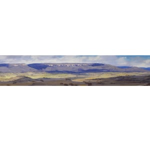 May include: A panoramic landscape painting depicting a distant mountain range with a blue-grey hue. The foreground features rolling hills in shades of green and brown, with a few scattered trees.