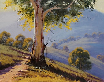 May include: A painting depicting a large tree with yellow leaves in the foreground, a dirt path leading up a hill, and a kangaroo in the distance. The background features a hazy blue sky with rolling hills.