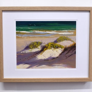 May include: A framed painting of a beach scene with green water, white sand dunes, and green shrubs. The painting is signed "J. Pedersen" in the lower right corner.