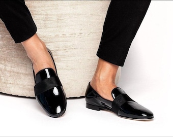 May include: A pair of black patent leather loafers with a black satin bow detail. The loafers have a pointed toe and a low heel.