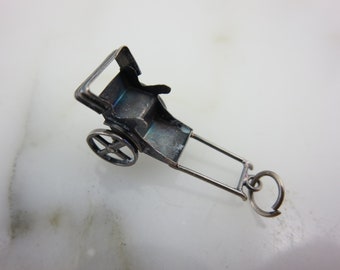 Peut inclure: Breloque en argent en forme de pousse-pousse. Le breloque a une seule roue et un design détaillé.