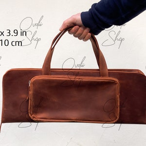 May include: A brown leather carrying case with a zippered pocket and a handle. The case measures 18.1 inches by 3.9 inches or 46 cm by 10 cm.