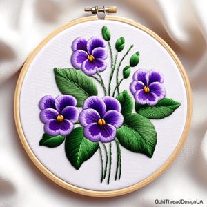May include: Embroidered hoop art featuring a bouquet of purple and green violets. The flowers are stitched with detail and the leaves are a vibrant green.