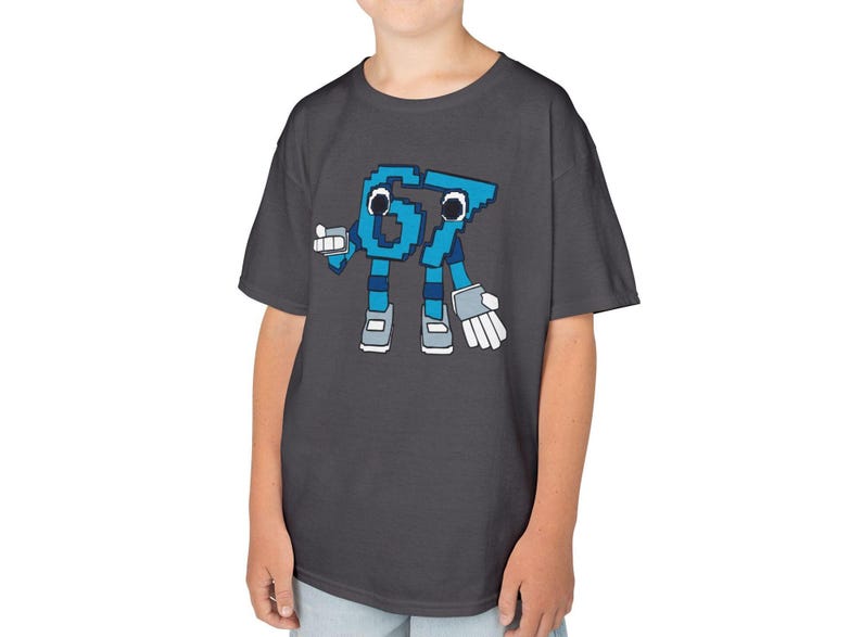 May include: Dark gray t-shirt featuring a pixelated cartoon character of the number 67 in blue. The character has arms, legs, and a friendly expression. The shirt is made of a soft material.