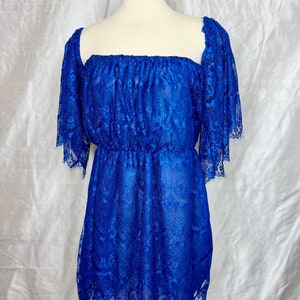 May include: A royal blue lace off-the-shoulder dress with short sleeves and a ruffled hem.