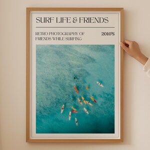 a woman standing next to a surf and Ocean poster on a wall
