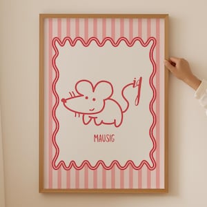 May include: A framed print with a cartoon mouse illustration in red. The mouse is drawn with simple lines and the word "MAUSIG" is below it. The background has pink and white vertical stripes, and the frame is a light brown colour.
