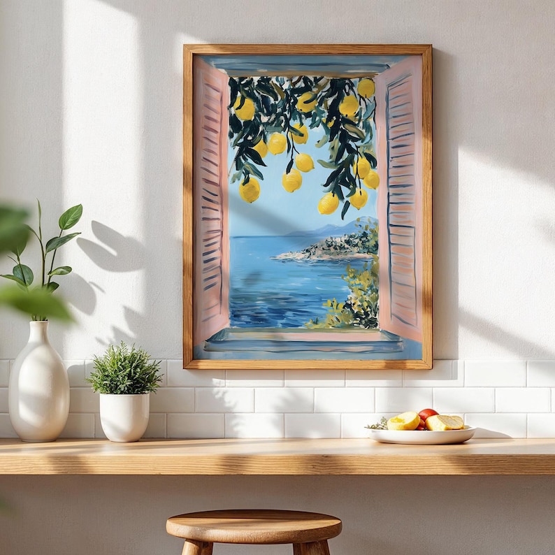 a framed painting of a scenic view of the sea with a lemon tree in the foreground, hanging on a white wall above a wooden shelf with a bowl of fruit and a potted plant.