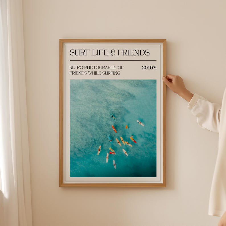 a woman standing next to a surf and Ocean poster on a wall