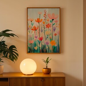 a painting of flowers on a wall next to a potted plant