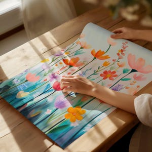 a person is painting flowers on a piece of paper