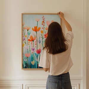 a woman standing in front of a painting on a wall