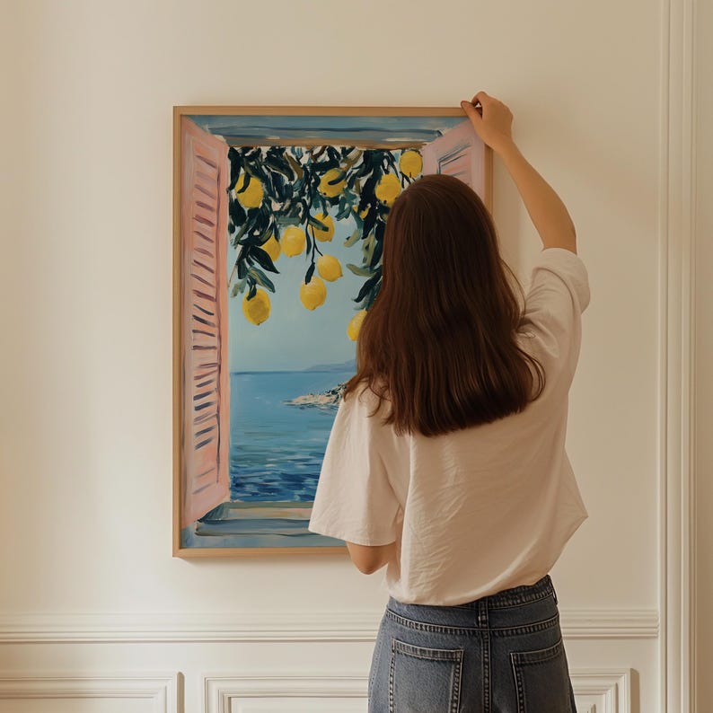 A woman is standing in front of a painting that depicts a window with a view of the ocean, hanging on a wall.