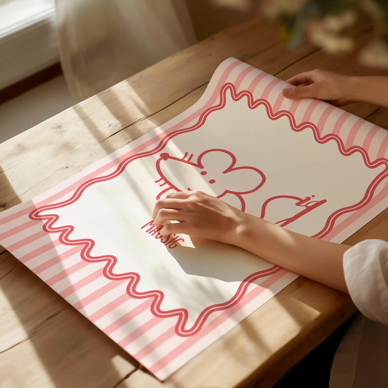 May include: A rolled-up mat with a pink and white striped border and a wavy pink outline. The mat features a cartoon mouse illustration and the word "MUSIC" in pink. The mat is on a wooden surface.