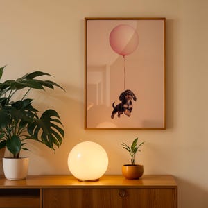 a picture of a dog with a balloon hanging on a wall