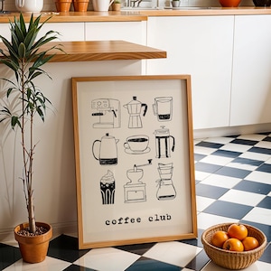 Könnte beinhalten: Ein Holzrahmen mit schwarz-weißen Strichzeichnungen von Kaffeezubereitungsgeräten, darunter eine Espressomaschine und eine Kaffeekanne. Der Text "coffee club" ist unten aufgedruckt. Der Rahmen lehnt an einer weißen Wand.