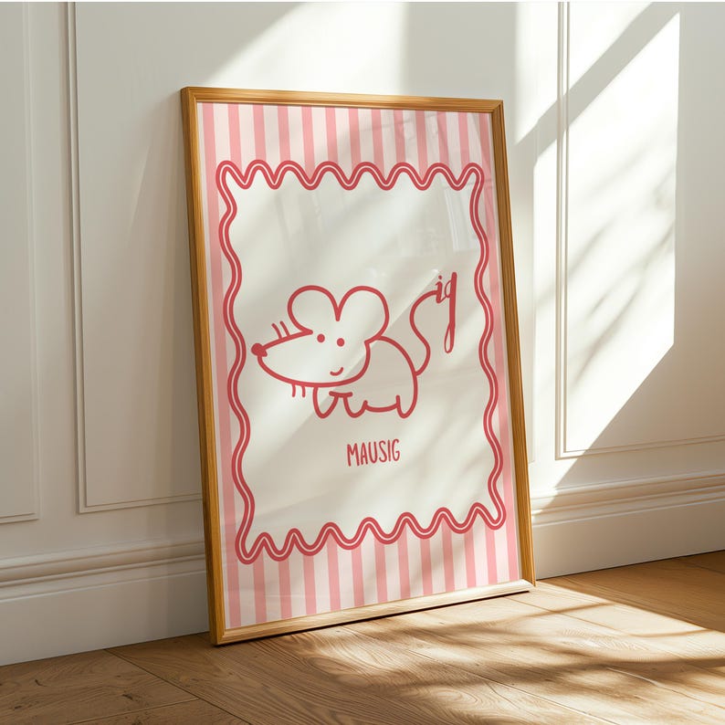 May include: Framed print with a red cartoon mouse illustration. The artwork has a white background with pink vertical stripes and a wavy pink border. The word "MAUSIG" is written below the mouse. The frame is wooden.
