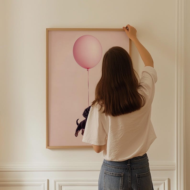 a woman is holding a balloon in front of a painting