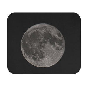 May include: A full moon in a dark night sky. The moon is a bright white with a grey surface and many craters.