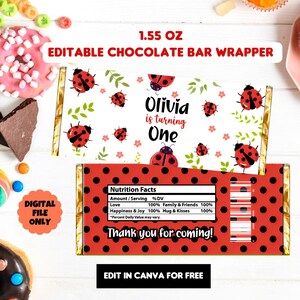 May include: A ladybug-themed chocolate bar wrapper. The wrapper displays red ladybugs, green leaves, and the text "Olivia is turning One." The reverse side has a red polka dot pattern and the words "Thank you for coming!"